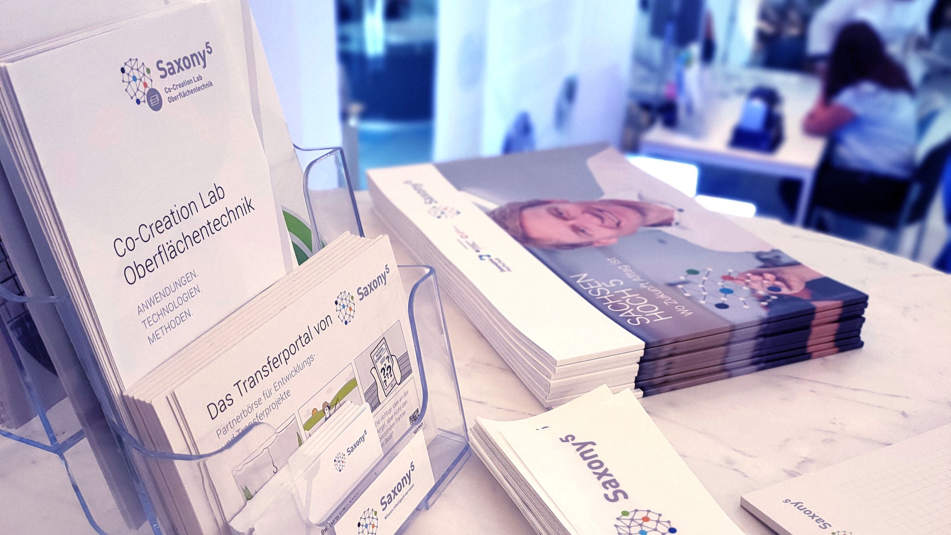Verschiedene Saxony high five Publikationen und Give-aways auf einem Tisch.